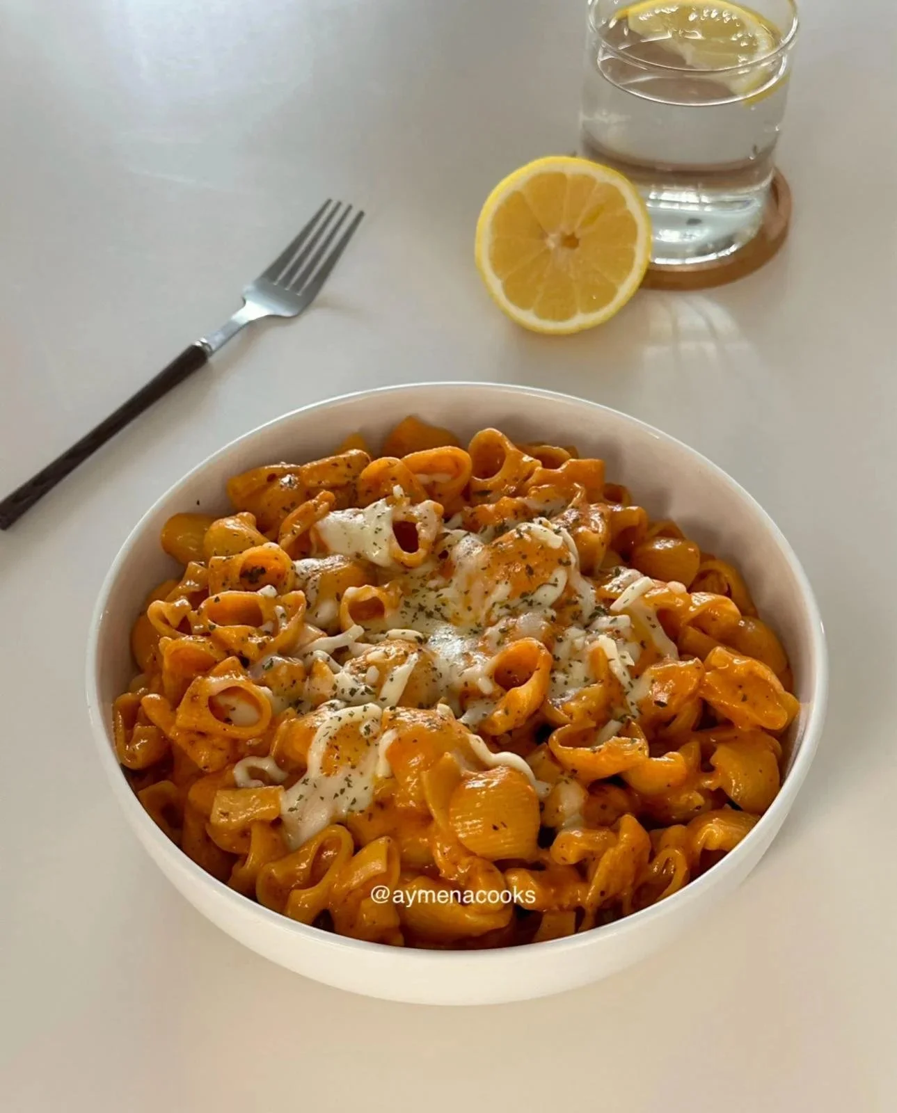 Creamy cheesy chicken pasta dish garnished with fresh herbs